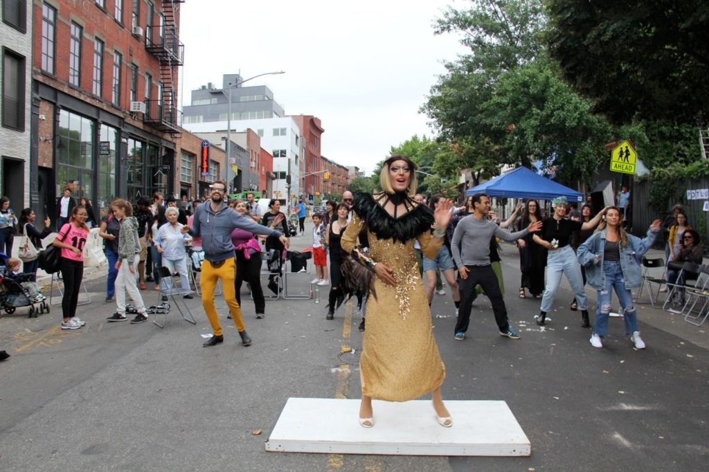 Mar leading zoomba class outside CAVE on Brooklyn street surrounded by happy followers